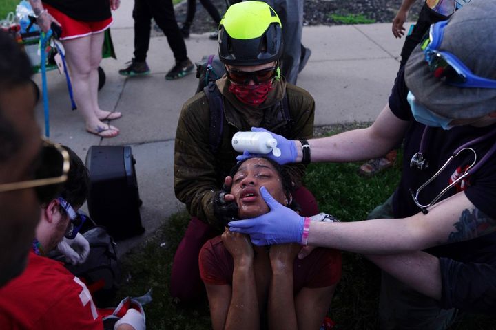 Citizen medics help a protester clear her eyes as police move in with tear gas against protesters near the Minneapolis Police 5th Precinct on May 30.