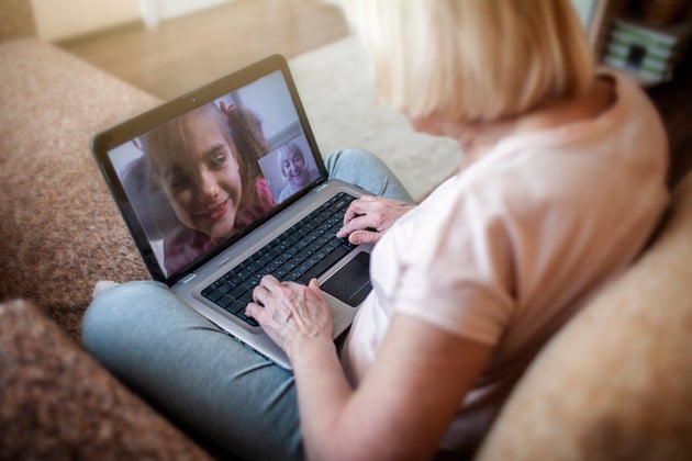 Cute girl talking with her grandmother within video chat on laptop, digital conversation, life in quarantine time, self-isolation