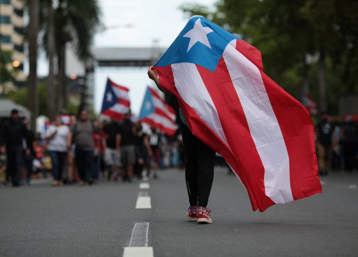 A person carries a Puerto Rican national flag during a protest against the government's austerity measures in 2017. 