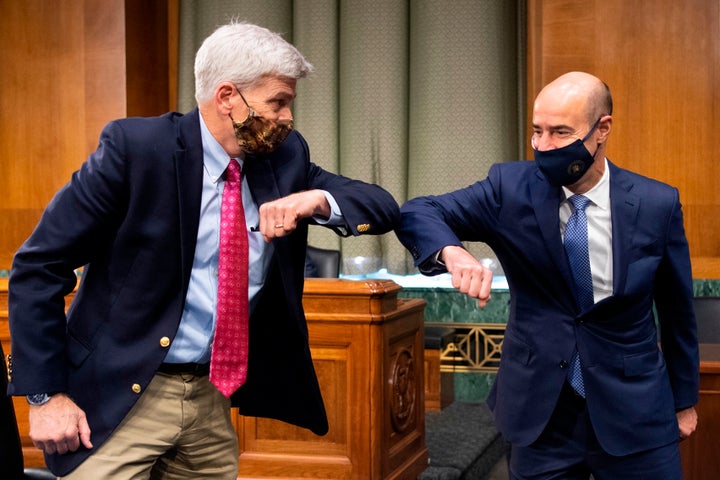 Sen. Bill Cassidy (R-La.), left, elbow-bumps Labor Secretary Eugene Scalia before the start of a Senate Finance Committee hea