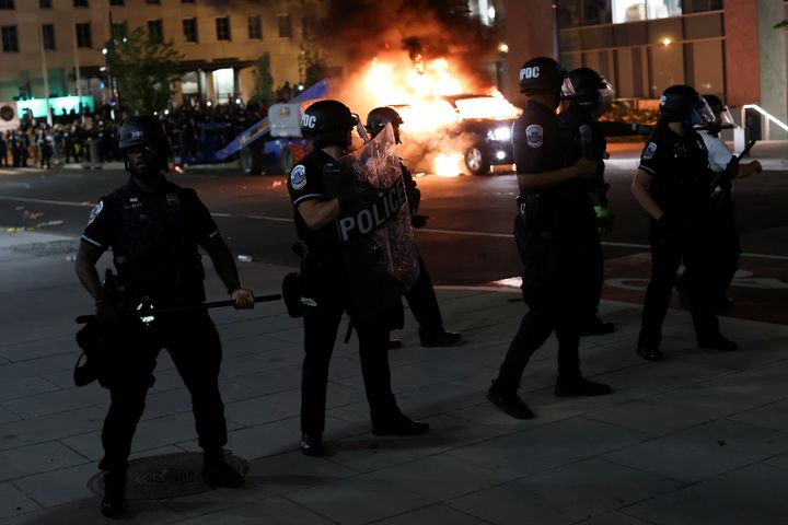 Police officers look on as a car burns in the back as protesters continue to rally against the death in Minneapolis police custody of George Floyd, near the White House, in Washington, U.S., May 30, 2020. (REUTERS/Jonathan Ernst)