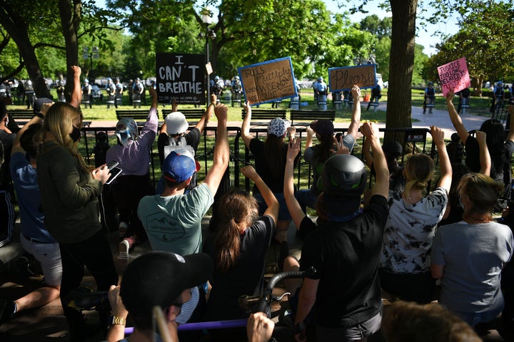 Protestors take a knee and raise their fists in Lafayette Square near the White House on June 1. The protesters were forced b