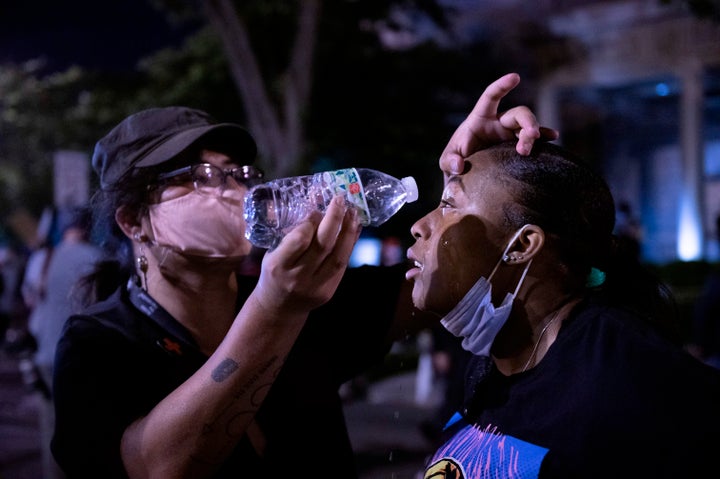 A protester rinses the eyes of another with water after police fired tear gas during a protest on May 31.