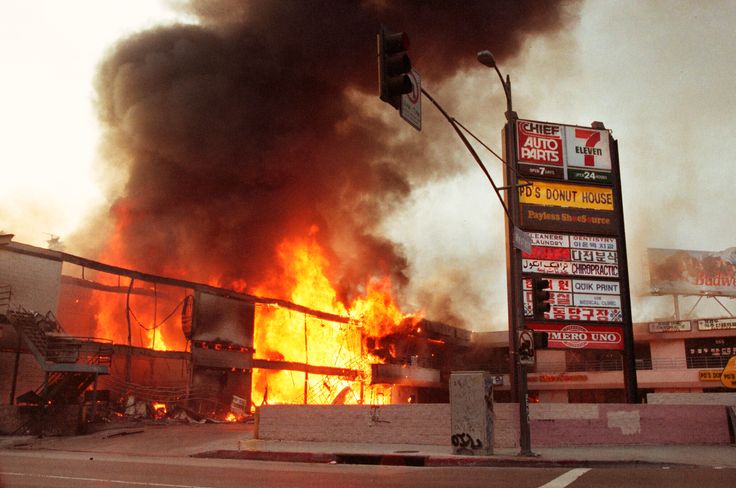 A corner shopping center in Koreatown is left burning out of control in Los Angeles on the third day of the 1992 Los Angeles uprising.