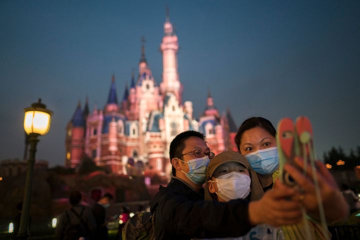Masked people visit Shanghai Disneyland after its reopening on May 11, 2020.
