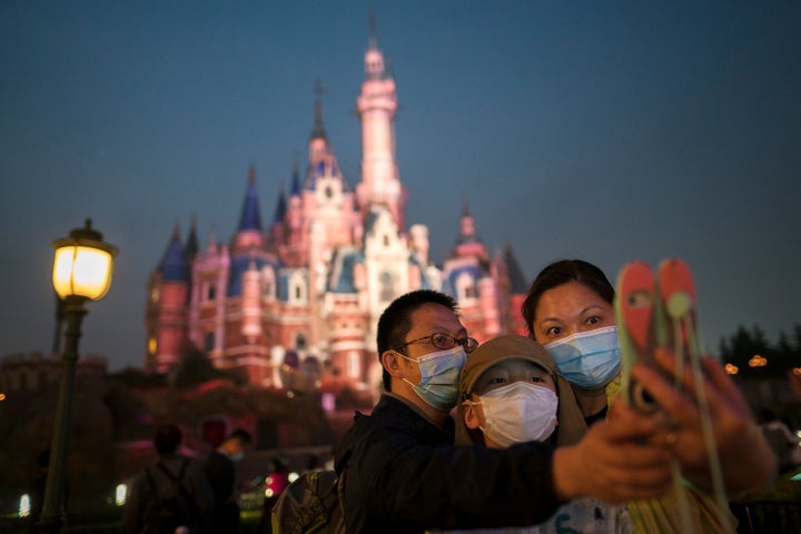 Experts Predict What Disney Parks Will Be Like Amid Coronavirus 3 Masked people visit Shanghai Disneyland after its reopening on May 11, 2020.