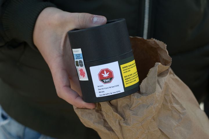 A man pulls a container of cannabis out of a bag after making a purchase in Quebec City in October 2018. A pilot project will allow same-day delivery for marijuana purchases in the province of Quebec.