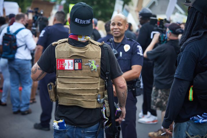A member of the far-right movement Boogaloo walks next to protestors outside a police station in Charlotte, North Carolina, on May 29.