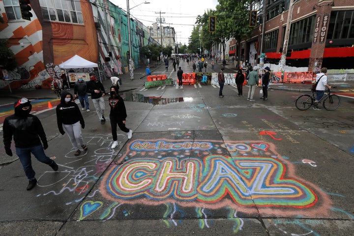 Sreet art reads "Welcome to CHAZ" on Thursday inside what is being called the Capitol Hill Autonomous Zone in Seattle. Following days of violent confrontations with protesters, police in Seattle have largely withdrawn from the neighborhood, and protesters have created a festival-like scene that has President Donald Trump fuming.