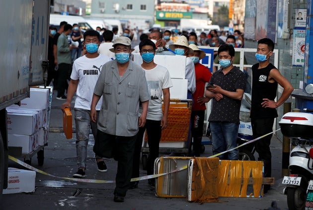 People wearing face masks inside the Jingshen seafood market which has been closed for business after...