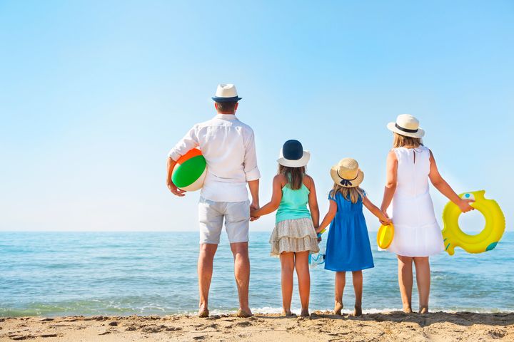 Young family with two children at beach. Holiday and travel concept
