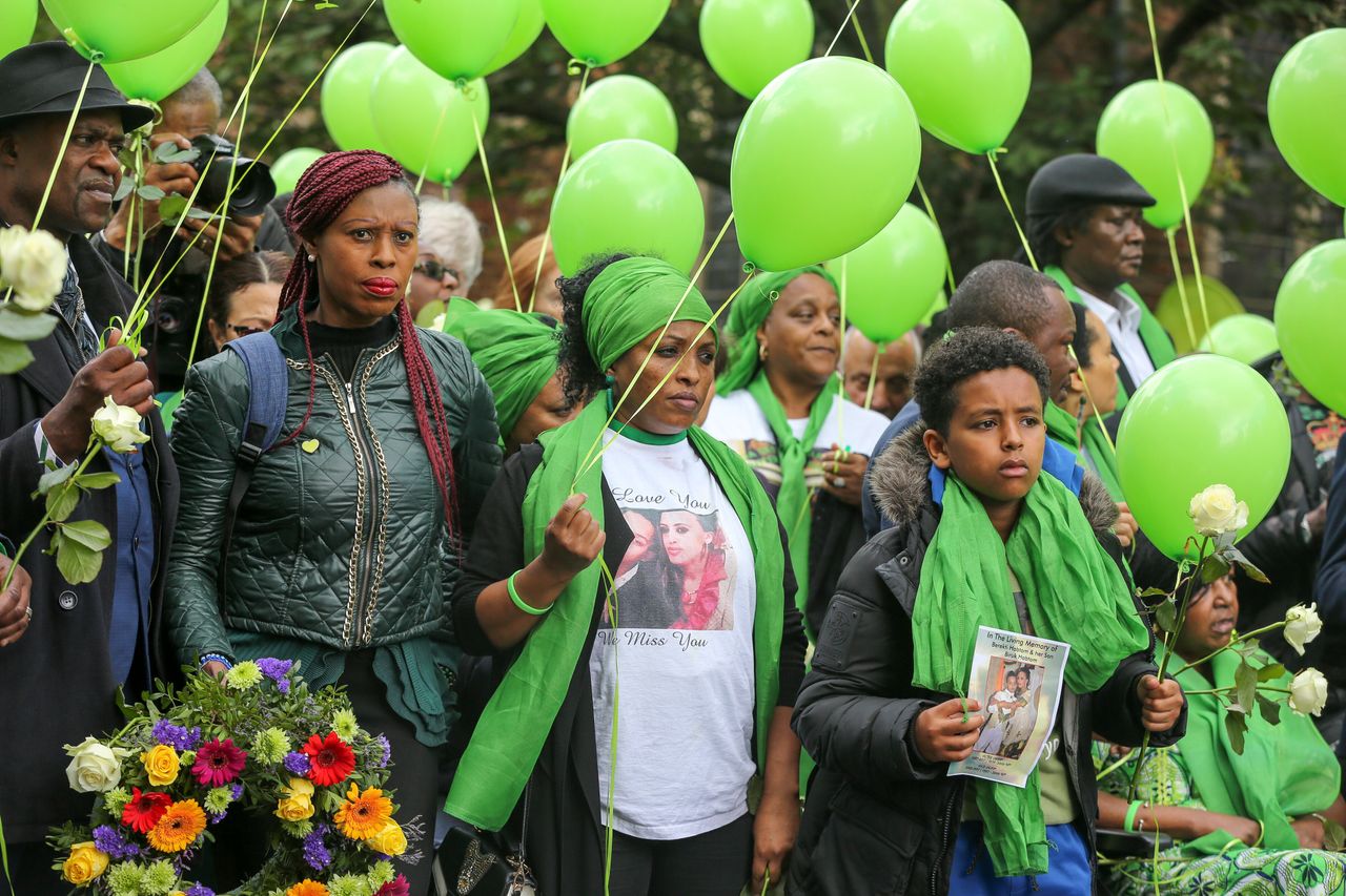 Survivors, family and friends of the victims wearing symbolic green scarves and holding green balloons at last year's commemorations
