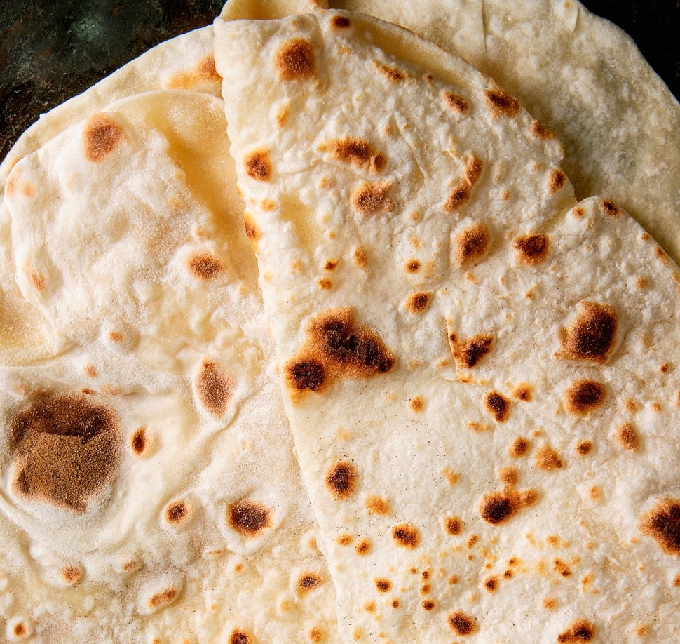 Homemade pita or chapati flatbread flapjack over dark metal background, Flat lay, close up. (Photo by: Natasha Breen/REDA&CO/Universal Images Group via Getty Images)