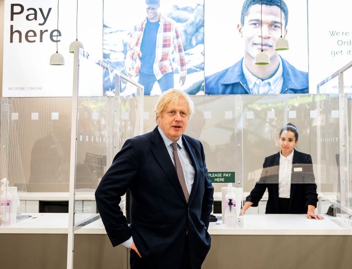 Britain's Prime Minister Boris Johnson visits a shop in Westfield Stratford shopping centre in east London, Sunday June 14, 2020, to see the preparations the stores are making to be COVID-19 secure, ahead of non-essential retail being able to reopen from Monday morning. (John Nguyen/Pool via AP)