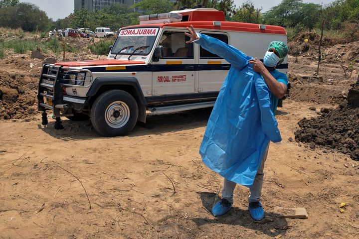 Mohammad Aamir Khan, an ambulance driver, changes his personal protective equipment (PPE) as he prepares to take out bodies of people who died due to the coronavirus disease (COVID-19), before their burial at a graveyard in New Delhi, June 8, 2020.