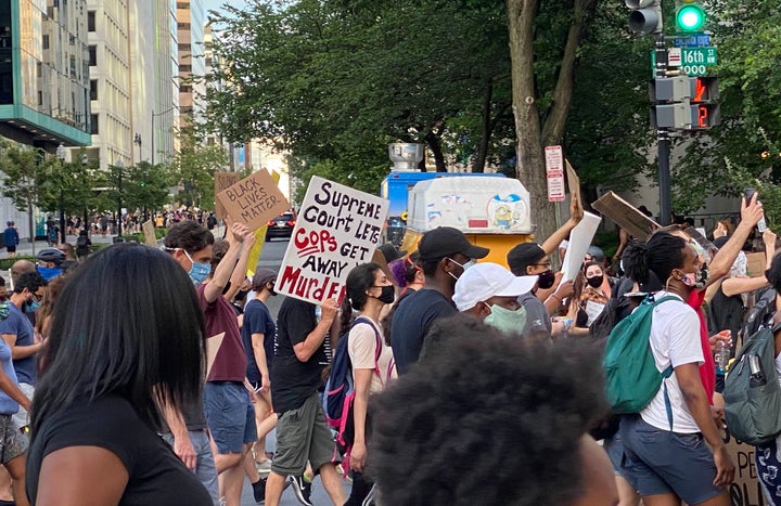 A protester carries a sign that reads "Supreme Court lets cops get away with murder" during a Black Lives Matter protest near