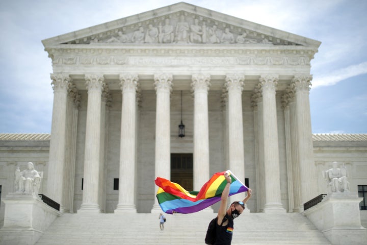 Joseph Fons, holding a Pride Flag, walks back and forth in front of the U.S. Supreme Court building after the court ruled tha