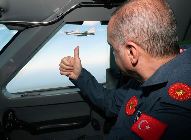 Turkish army jet fighters escort the plane of Turkey's President Recep Tayyip Erdogan, gestures as he arrives at the new airport in Istanbul, Saturday, Sept. 22, 2018, to attend the Teknofest aviation, space and technology fair. The fair is taking place between Sept. 20-23 at Istanbul's new international airport, still under construction.(Presidential Press Service via AP, Pool)