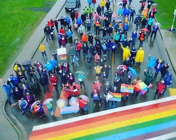 Residents of Dawson Creek gather for a photo near the city's rainbow crosswalk. 