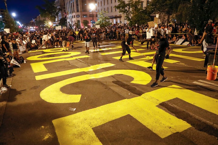 Demonstrators paint the words 'defund the police' as they protest June 6 near the White House in Washington, D.C., over the death of George Floyd.