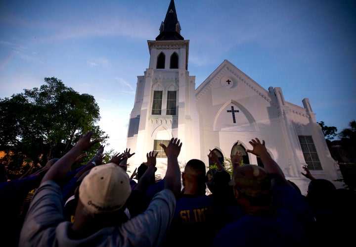 The men of Omega Psi Phi Fraternity Inc. lead a crowd of people in prayer outside the Emanuel AME Church in June 2015 after a memorial in Charleston, South Carolina.