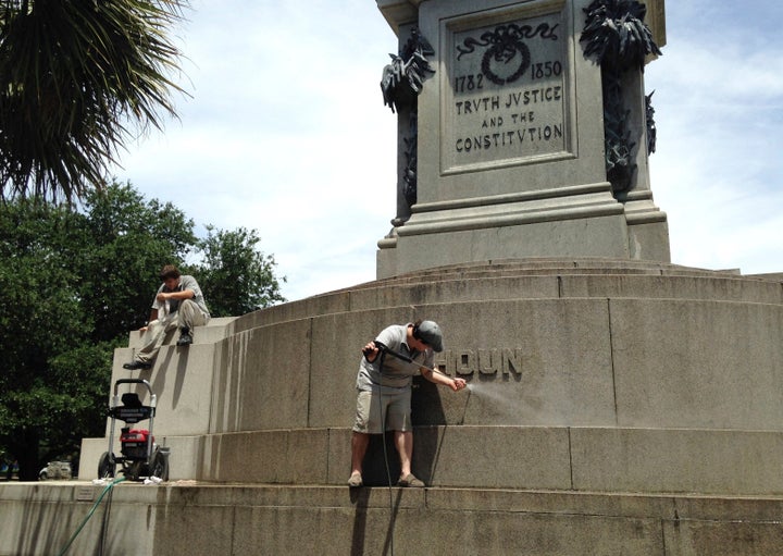 In this June 23, 2015, file photo, Joe Patrizzi III power-washes graffiti from a statue in Charleston, South Carolina, of John C. Calhoun, who was a vice president, U.S. senator and congressman from South Carolina. The statue was defaced with the words "racist" and "slavery."