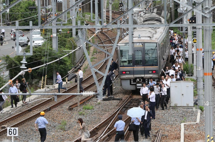 線路の横を歩いてJR新大阪駅に向かう乗客＝2018年6月18日、大阪市淀川区