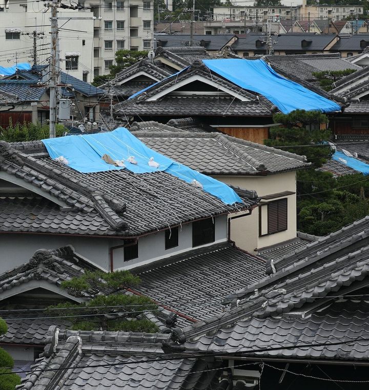 地震で破損し、ブルーシートが掛けられた住宅の屋根＝2018年6月19日、大阪府高槻市