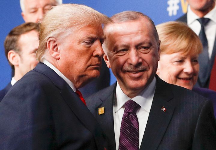 Donald Trump with Turkey's President Recep Tayyip Erdogan at the NATO summit, with German Chancellor Angela Merkel in the background 