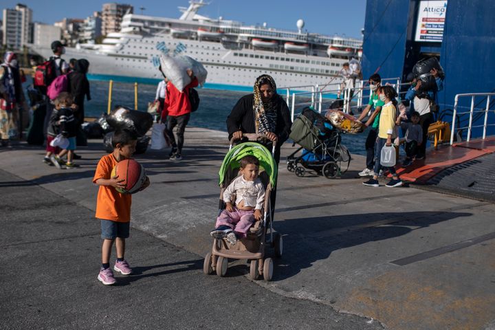 Refugees and migrants wearing masks arrive at the port of Piraeus , near Athens, on Thursday, June 11, 2020. Greek authorities are moving about 180 migrants, to the mainland to help ease overcrowded conditions at the camp Moria in Lesbos island. (AP Photo/Petros Giannakouris)