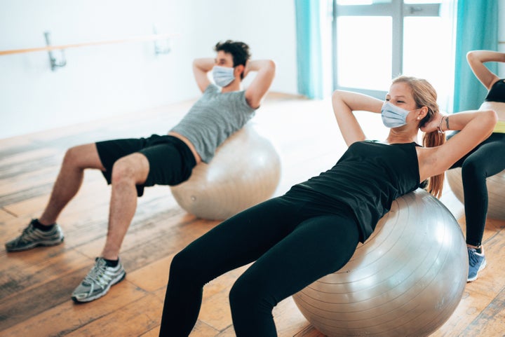 Un hombre y una mujer hacen ejercicio en un gimnasio.