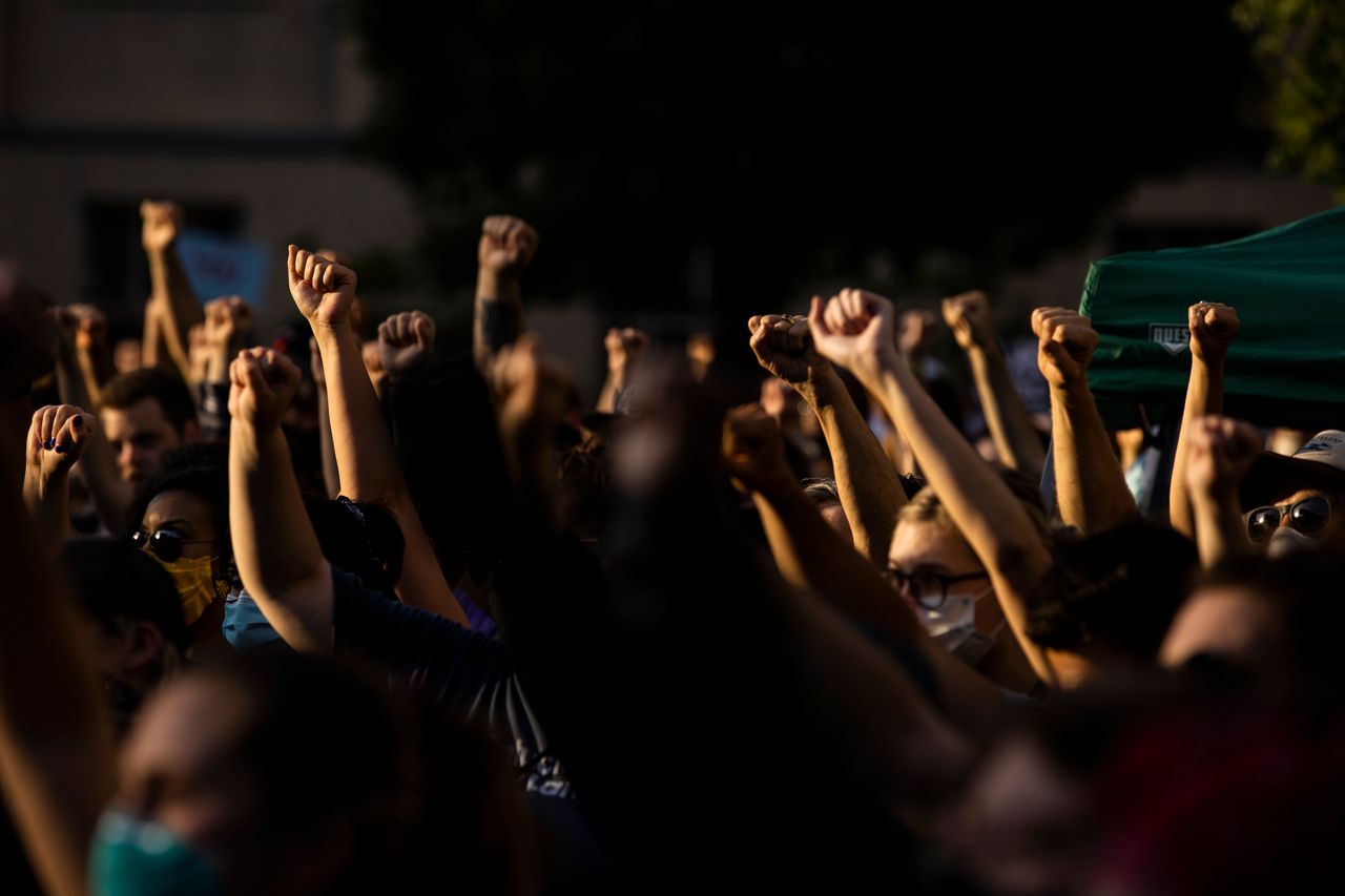 Protesters raise their fists in solidarity while listening to a speaker on June 5 in Louisville, Kentucky. Booker's presence at the ongoing protests has given a huge boost to his campaign.