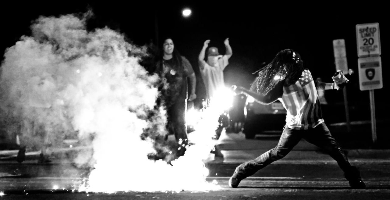 Edward Crawford Jr. returns a tear gas canister fired by police who were trying to disperse protesters in Ferguson, Missouri, on Aug. 13, 2014.