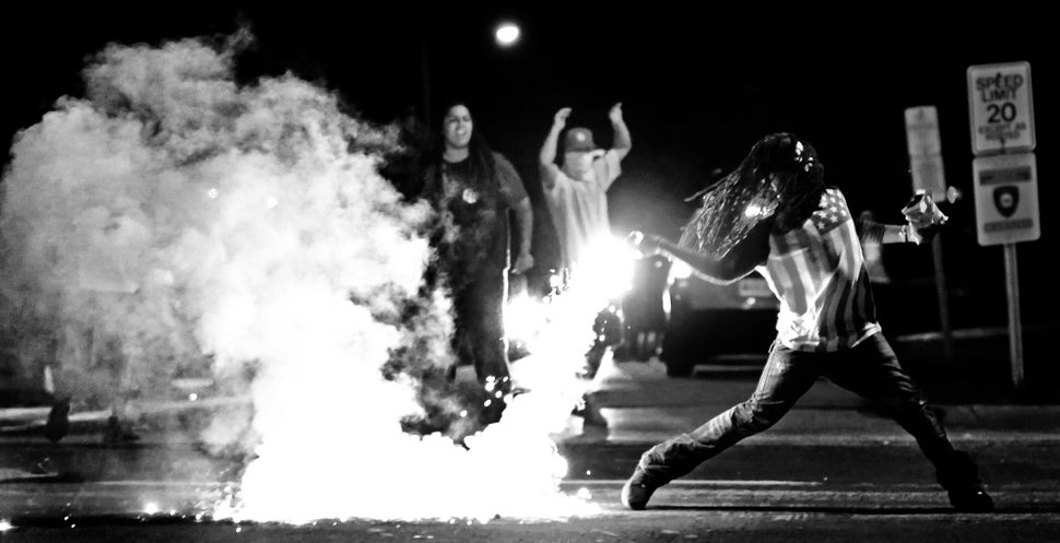 Edward Crawford Jr. returns a tear gas canister fired by police who were trying to disperse protesters in Ferguson, Missouri,