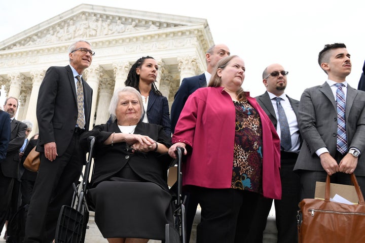 Aimee Stephens, seated, and her wife Donna Stephens, in pink, listen during a news conference outside the Supreme Court on Oct. 8, 2019. Stephens' former employer unsuccessfully argued in a lower court that RFRA allowed him to fire her.