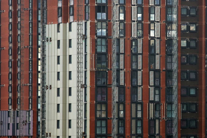 A high-rise building is seen with cladding in the process of being removed.