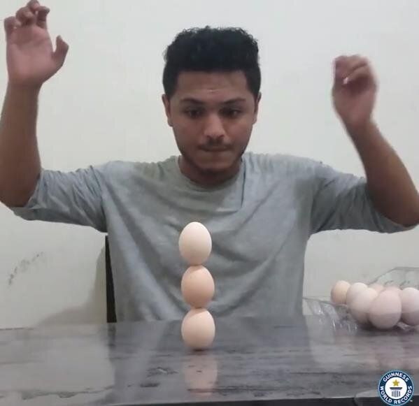 계란 3개를 수직으로 쌓아올린 남성 