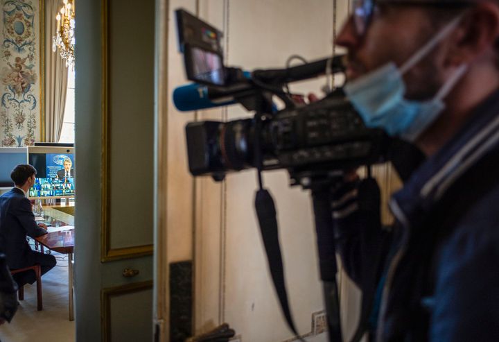 Παρίσι, 19 Ιουνίου 2020. Κάμεραμαν με μάσκα στο πρόσωπο ετοιμάζεται να βιντεοσκοπήσει τον Γάλλο Πρόεδρο καθώς ετοιμάζεται για την τηλεδιάσκεψη με τους Ευρωπαίους ηγέτες. (Eliot Blondet/Pool Photo via AP)
