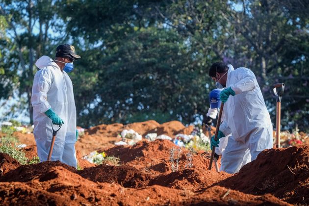 Cemetery workers in protective suits shovel earth at the Vila Formosa cemetery in the Brazilian city of Sao Paulo amid the coronavirus pandemic.