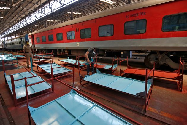 A worker paints beds to be used at a railway hospital in Chennai, India, to accommodate coronavirus patients, March 30.