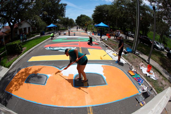 An artist painting part of the new Black Lives Matter street mural in front of the Dr. Carter G. Woodson African American Museum in St. Petersburg, Florida, this week. The project was meant to be completed before the city's Juneteenth celebrations on Friday.