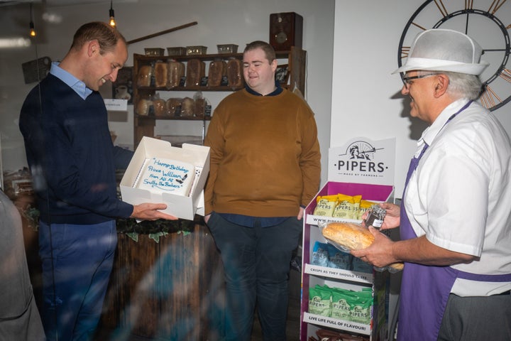 William is presented with a birthday cake by shop owner Paul Brandon (right).