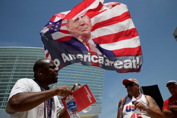 Nicholas Winford, left, debates Trump supporter Randall Thom, right, on the racial policies of President Donald Trump outside