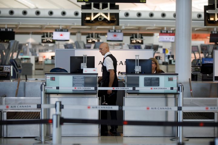 An Air Canada employee at a quiet check-in counter at Toronto Pearson International Airport, on April 1, 2020.