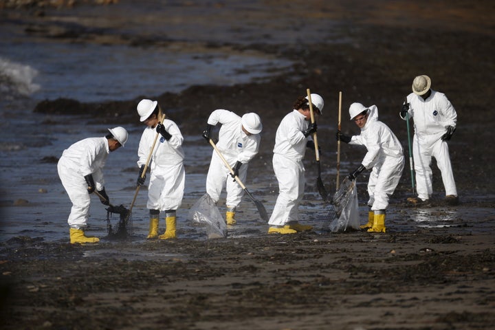 Workers clean an oil spill on a California beach. There's plenty more work where that came from.