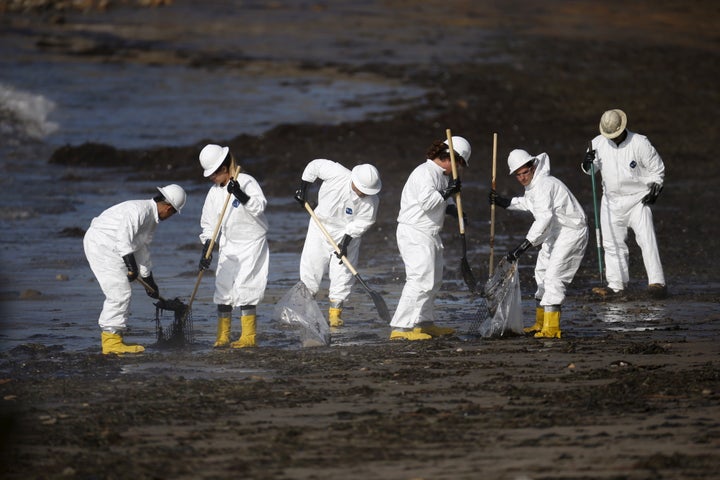 Workers clean an oil spill on a California beach. There's plenty more work where that came from. 