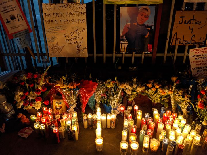 Candles and flowers are set next to an image of Andres Guardado.