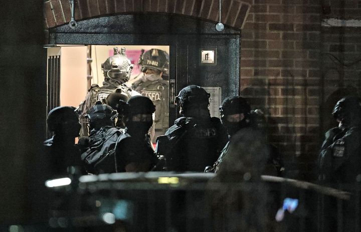 Armed police officers investigate at a block of flats off the Basingstoke Road in Reading.