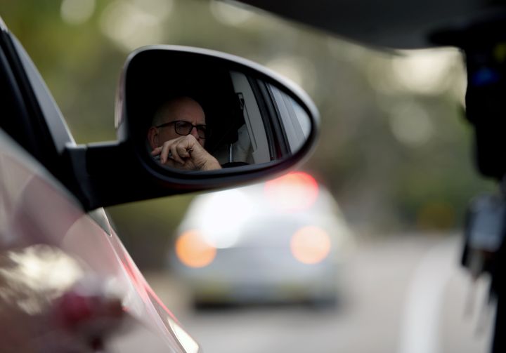 A motorist waits in a car as he crosses into South Australia from Victoria during the coronavirus disease (COVID-19) outbreak, in Bordertown, Australia, March 24, 2020. REUTERS/Tracey Nearmy/Files