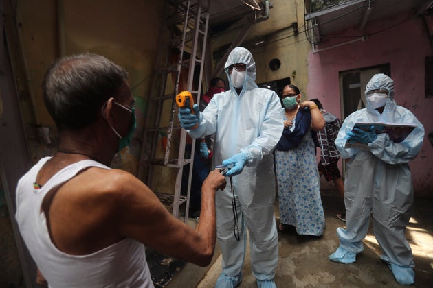 A doctor checks the temperature of a man in Mumbai, India, on June 20,